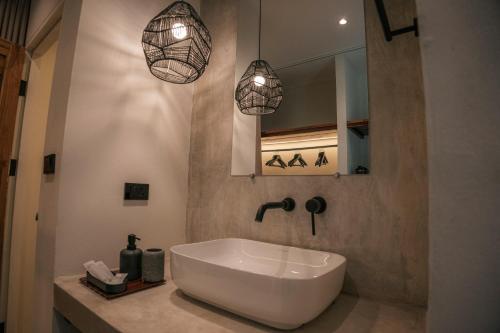 Un baño con lavabo blanco y dos lámparas colgantes en KAI BAE BALCONY Hills Bungalows Koh Chang, en Khlaung Phai Bae
