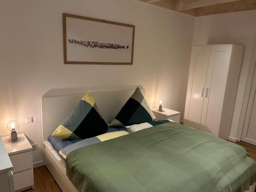 ein Schlafzimmer mit einem grünen Bett mit zwei Nachttischen in der Unterkunft Apartment Deich - Moment in Krummendeich