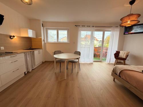 Zimmer mit einem Tisch, einer Küche und einem Bett in der Unterkunft Le clos des roses in Ingersheim