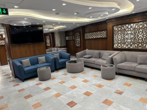 a lobby with couches and a flat screen tv at فندق لؤلؤة الجوار مكه in Makkah