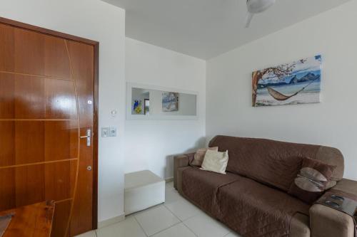 ein Wohnzimmer mit einem braunen Sofa und einem Schrank in der Unterkunft Praia Ubatuba Apartamento SilBraSil in Ubatuba
