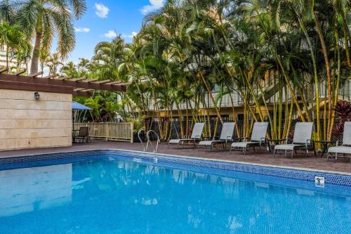 a swimming pool at a resort with chairs and palm trees at Wyndham Vacation Resorts Royal Garden at Waikiki in Honolulu