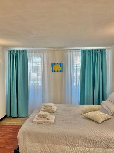 una camera da letto con tende blu e un letto con asciugamani di Sea Breeze a Riomaggiore
