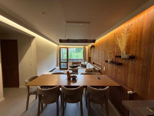 Un comedor con mesa y sillas de madera. en Appart 60 M2 pied pistes terrasse Vars les Claux, en Vars