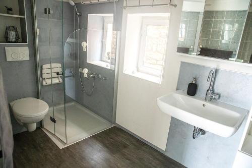 a bathroom with a shower and a sink and a toilet at Ferienhaus Lotte in Vöhl