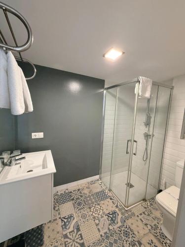 a bathroom with a shower and a sink and a toilet at Pescadors Apartamentos TRG in Benidorm