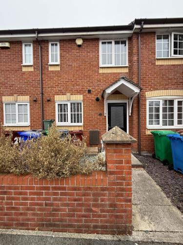 a red brick house with a brick wall at Stunning house in Chorlton in Manchester