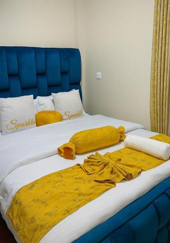 a bed with a blue headboard and yellow sheets at Kitengela Homes in Kitengela 