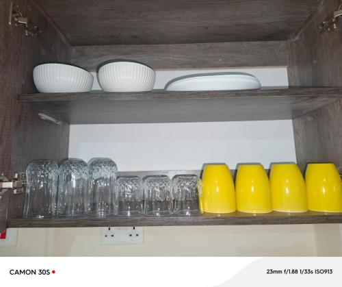 a shelf with wine glasses and bowls on it at Kitengela Homes in Kitengela 