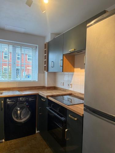 a kitchen with a dishwasher and a washer at Stunning house in Chorlton in Manchester