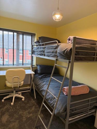 a room with bunk beds and a desk and a chair at Stunning house in Chorlton in Manchester