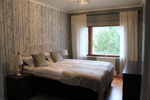 a bedroom with a large bed and a window at Cozy and spacious country house in Kakskerta in Turku