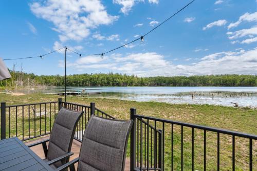 ゲイロードにあるQuiet and Cozy Lakefront Home Near Mt Boyneの湖の景色を望むデッキ(椅子2脚付)