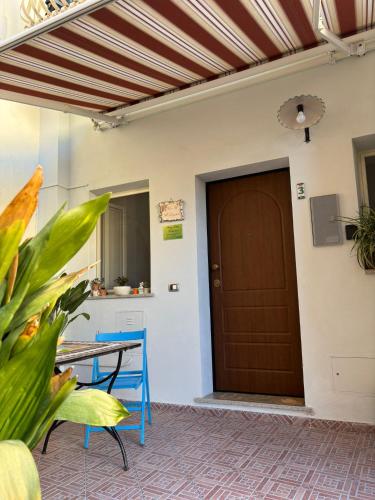 eine Terrasse mit einem Tisch und einer braunen Tür in der Unterkunft Al Larghetto in Lamezia Terme