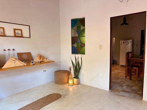 a living room with a potted plant and a painting on the wall at Casa Indigo Blue Jeri in Jericoacoara