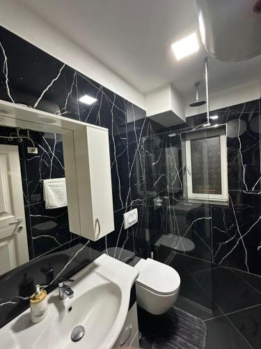 a bathroom with a white sink and a toilet at Gledys House in Krujë