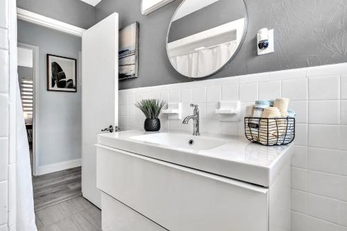 a white bathroom with a sink and a mirror at 3br Villa W Fire Pit By Hard Rock Hotel & Casino in Fort Lauderdale