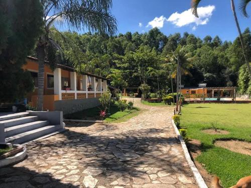 a house with a garden and a grass field at Pousada Chalés Sierra in Serra Negra