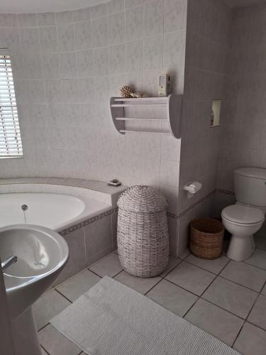 a bathroom with a tub and a toilet and a sink at See-Rus Self Catering Seaside Accommodation in Jacobs Bay
