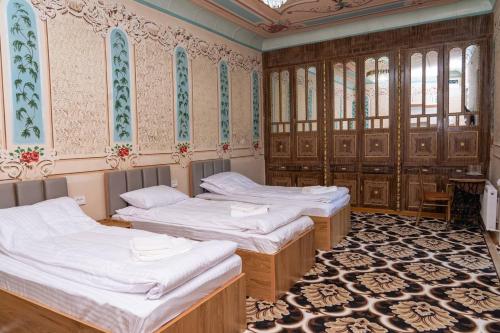 Zimmer mit 3 Betten und einem Zimmer mit Fenstern in der Unterkunft Orzu Guest House in Samarkand