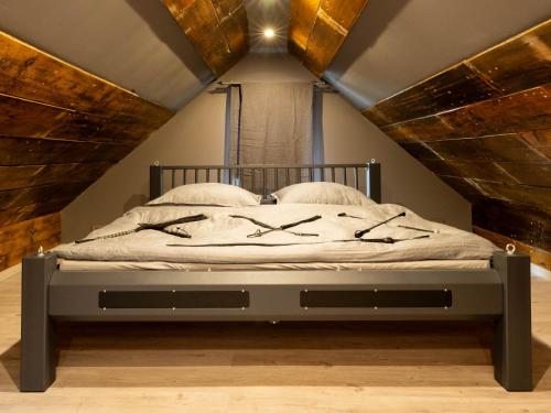 a bedroom with a bed with a wooden ceiling at Verdorbene Welten in Schönheide