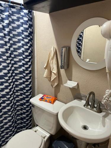 une salle de bain avec toilettes, lavabo et miroir dans l'établissement Casitapp punto com punto mx, à Tijuana