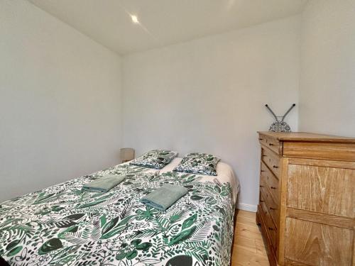 a bedroom with a bed and a wooden dresser at L'Appartement du Port in Étaples
