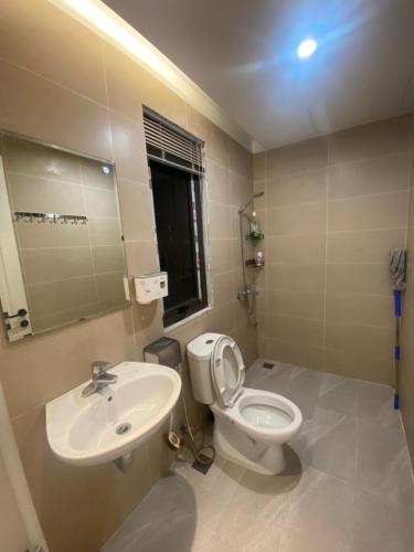 a bathroom with a sink and a toilet and a mirror at Hana Farm in Hanoi