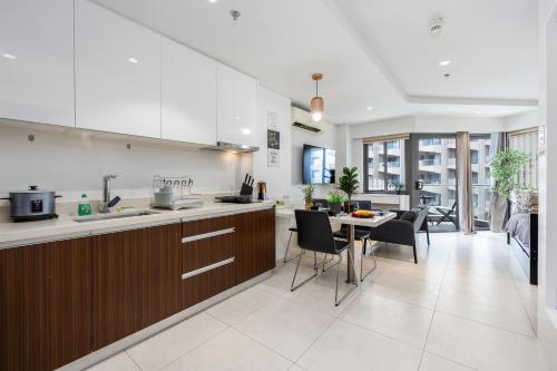 a kitchen and dining room with a table and chairs at Dominiks quite and Elegant Studio Ocean View Pool at Tambuli Resort High Floor in Maribago