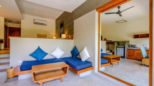 a living room with a blue couch and a table at Sea Dance Resort in Choeng Mon Beach