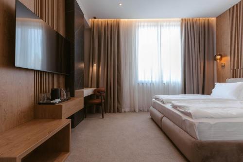 a hotel room with a bed and a window at Tradicija Hotel in Železnička Stanica Incel