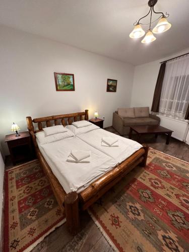 a bedroom with a large bed and a couch at Piramis Pihenőpark in Demjén