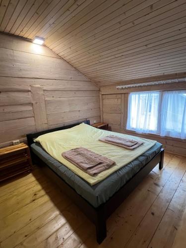 a bedroom with a bed in a wooden cabin at Будиночок над річкою in Korchin