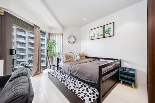 a bedroom with a bed and a couch at Dominiks quite and Elegant Studio Ocean View Pool at Tambuli Resort High Floor in Maribago