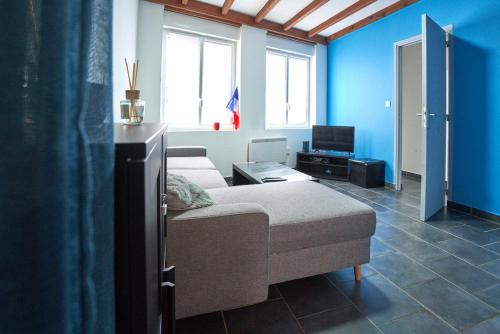 ein Wohnzimmer mit einem Bett und einem Fernseher in der Unterkunft Maison 2 ch, 3 lits, près de Lille & transports in Lezennes