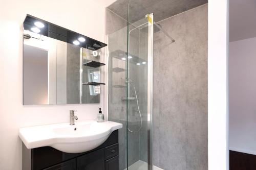 ein Badezimmer mit Waschbecken und Glasdusche in der Unterkunft Maison 2 ch, 3 lits, près de Lille & transports in Lezennes
