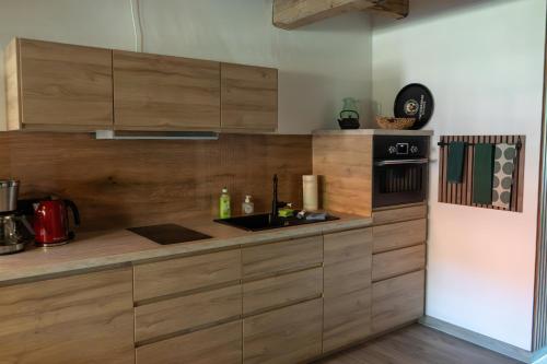 a kitchen with wooden cabinets and a sink at Eiche - Ferienwohnung in Dötlingen mit Waldblick in Dötlingen