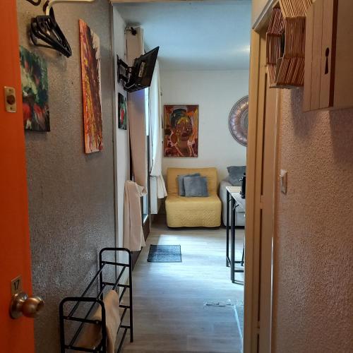 a hallway with a living room with a yellow couch at Studio SAFARI in Superbagnères