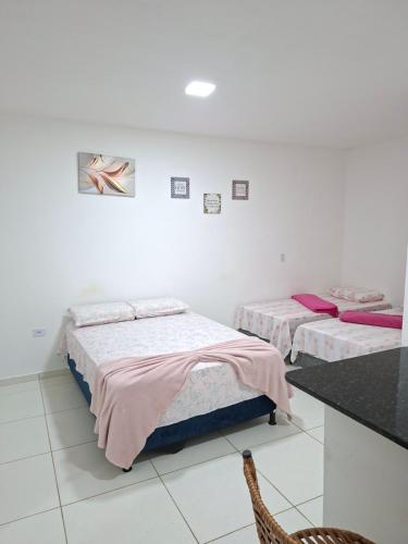 Una habitación con dos camas y una silla dentro. en pousada beira mar suites São Bento, en Maragogi