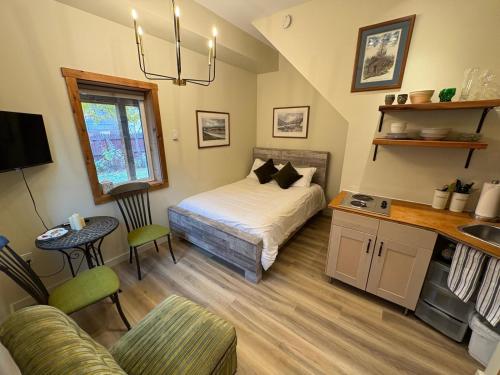 ein kleines Schlafzimmer mit einem Bett und einer Küche in der Unterkunft Located in Downtown Whitehorse - Basekamp in Whitehorse