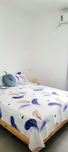 a bed with a blue and white comforter on it at Apartamento Azul - Bayahíbe in Bayahibe