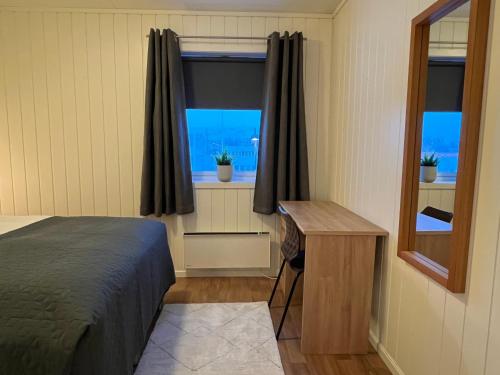 a bedroom with a bed and a desk and a window at Tanabrew in Tana