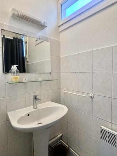 a white bathroom with a sink and a mirror at Le Nid du Port in Étaples