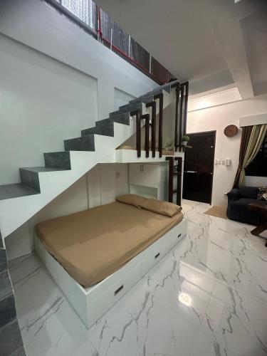 a bedroom with a bed under a staircase at Amado Apartelle 1 Tagaytay in Kaybagal