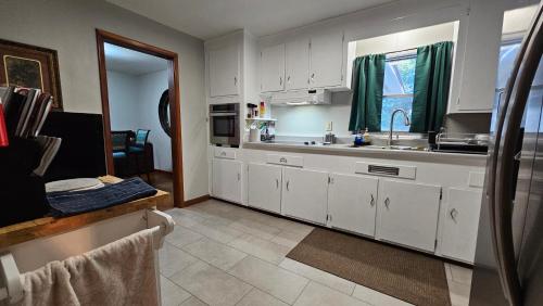 a kitchen with white cabinets and a sink at Charlotte's House in Jacksonville