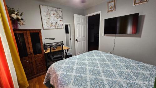 a bedroom with a bed and a flat screen tv at Charlotte's House in Jacksonville