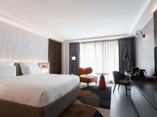 una camera d'albergo con un letto e una scrivania di Pullman Kinshasa Grand Hotel a Kinshasa