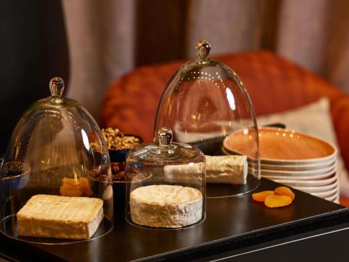 a tray with cheese and glass domes on a table at Cures Marines Hotel Thalasso & Spa Trouville - MGallery Collection in Trouville-sur-Mer