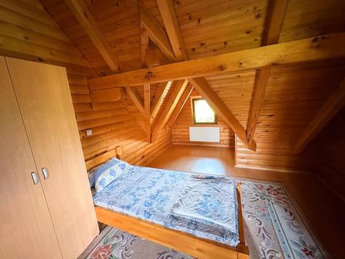 una camera con un letto in una cabina di legno di Vikendica sa bazenom Cazin Pecigrad a Cazin