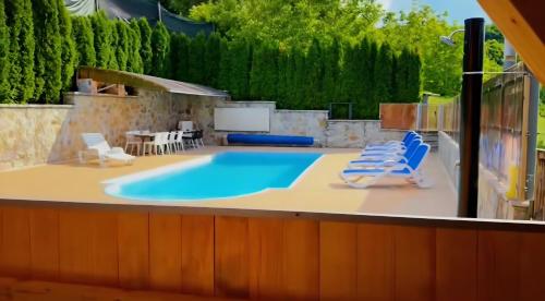 una piscina con due sedie a sdraio e un tavolo di Vikendica sa bazenom Cazin Pecigrad a Cazin